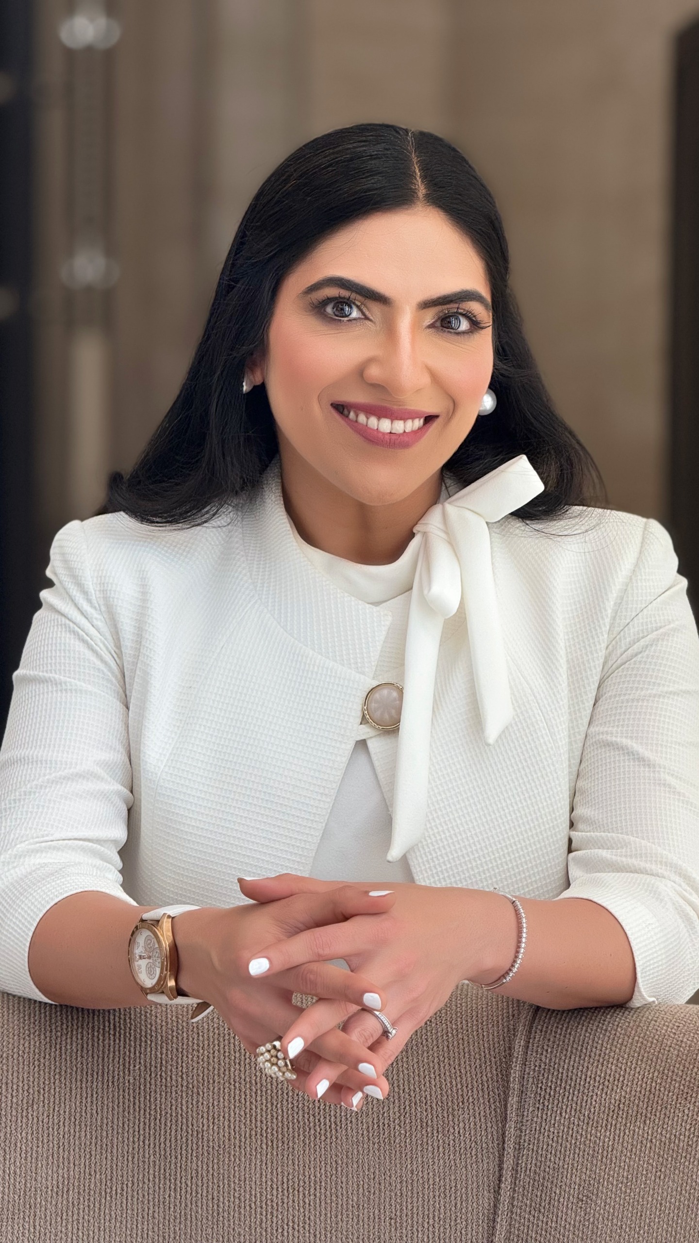 Maitri Somaia smiling in a white jacket — UAE-based event emcee and presenter